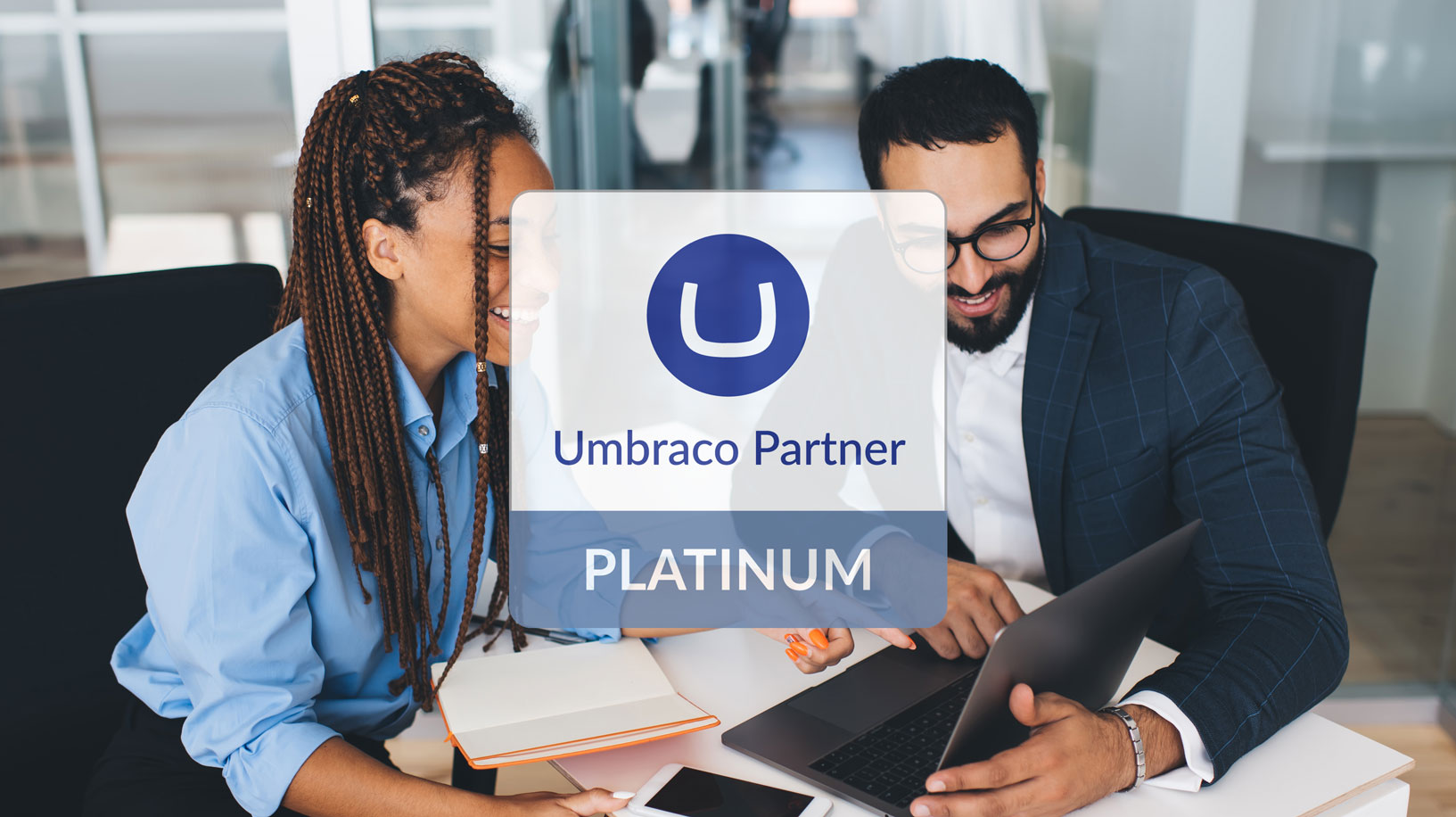 Two people - woman and man are having a meeting and pointing at the laptop screen. Umbraco Partner - Platinum