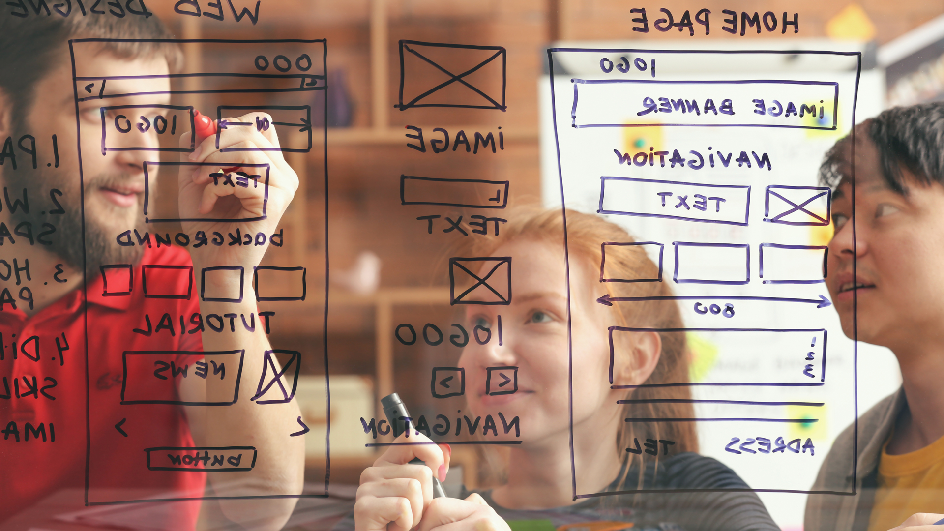 Web designers are discussing new application by drawing on the glass.