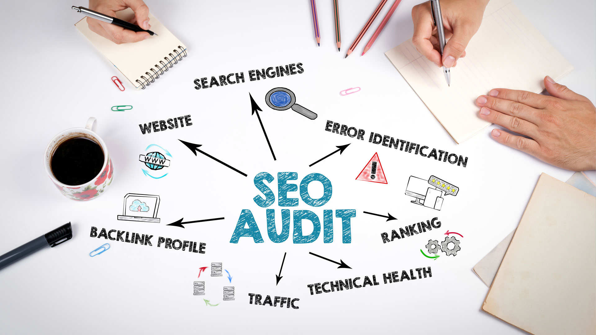 SEO audit title written on the table and illustrations representing SEO sections, with people hands holding pens and a coffee cup.