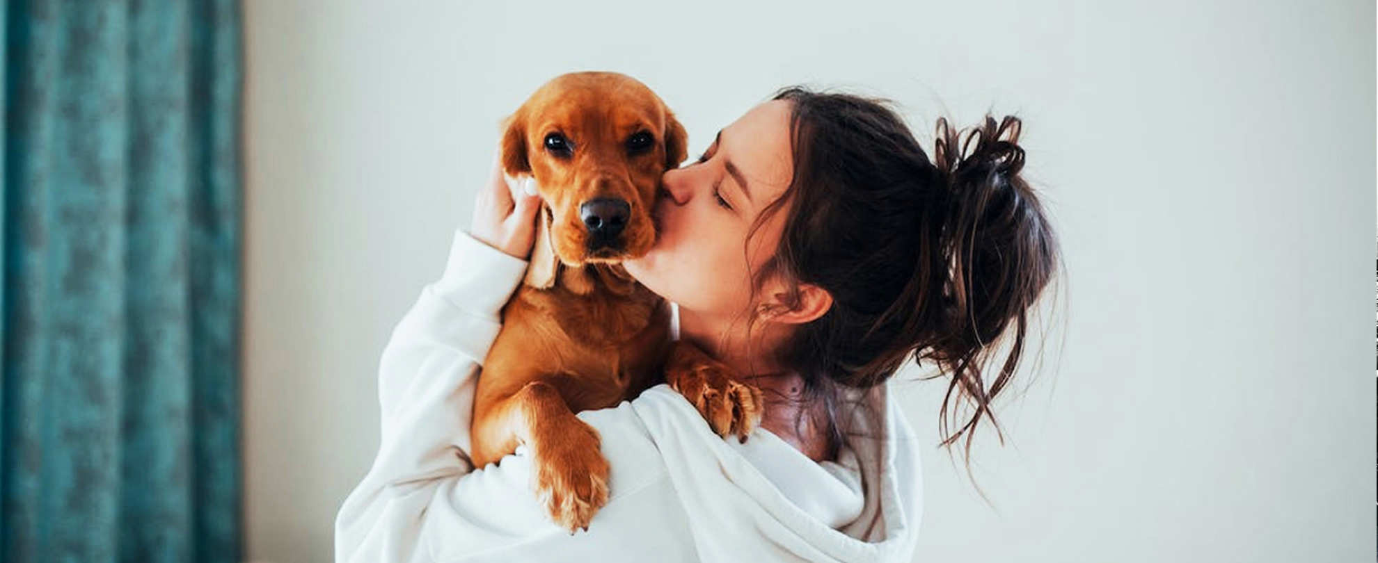 Woman kissing a puppy