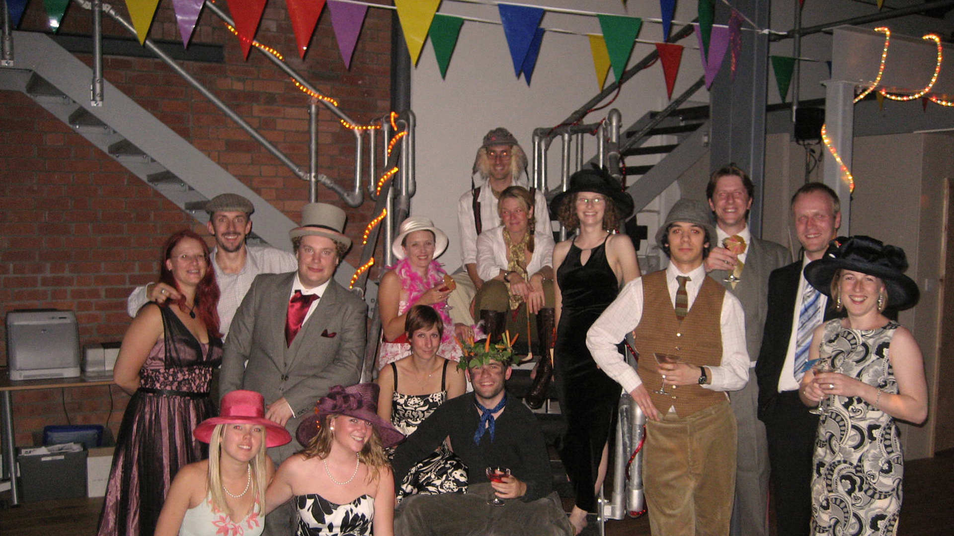 A group of people dressed in a fancy clothes are posing for a photo