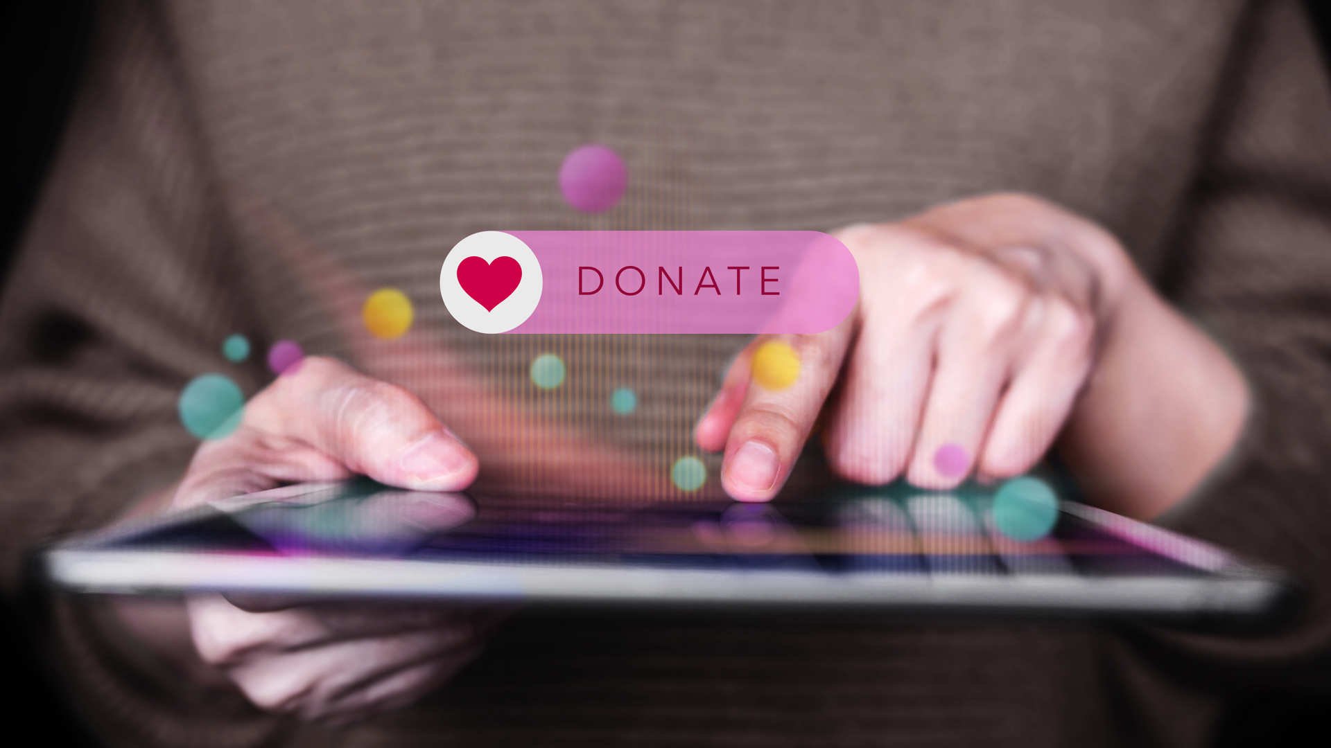 Hands touching the tablet device and Donate button is appearing above