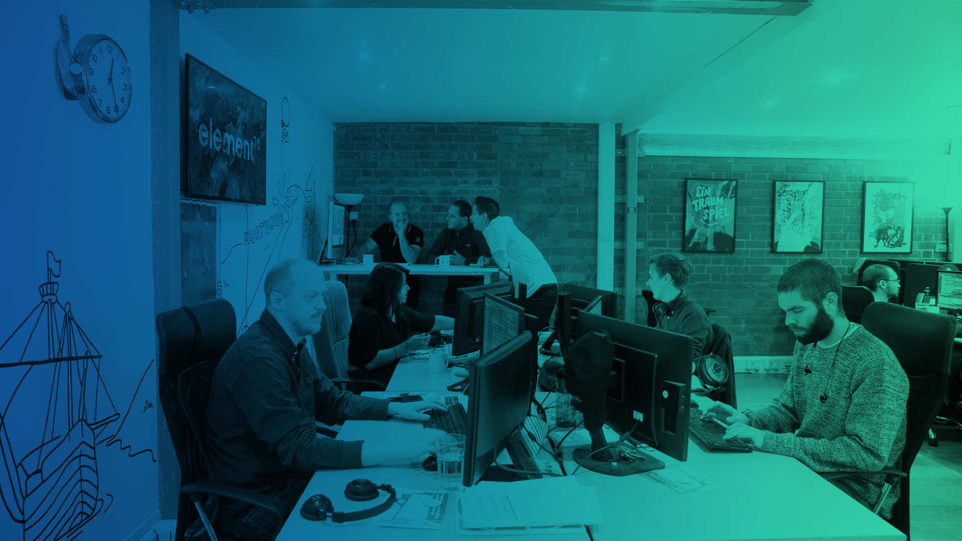 A group of people working at computers in the office.